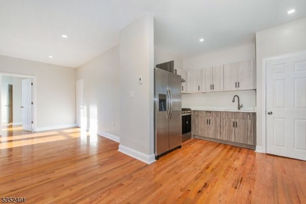 Empty room, Interior, Kitchen, Recessed Lighting, Stainless Steel Appliances, Wood Texture Flooring