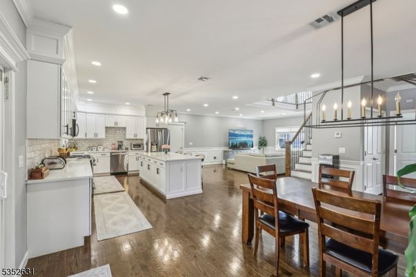Chandelier, Dining room, Interior, Kitchen, Living room, Pendant Lights, Recessed Lighting, Stainless Steel Appliances, Wood Texture Flooring