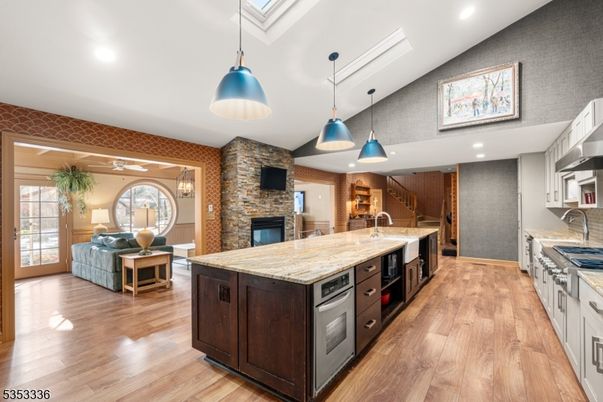 Fireplace, Interior, Kitchen, Living room, Pendant Lights, Recessed Lighting, Stainless Steel Appliances, Stone Walls, Wood Texture Flooring