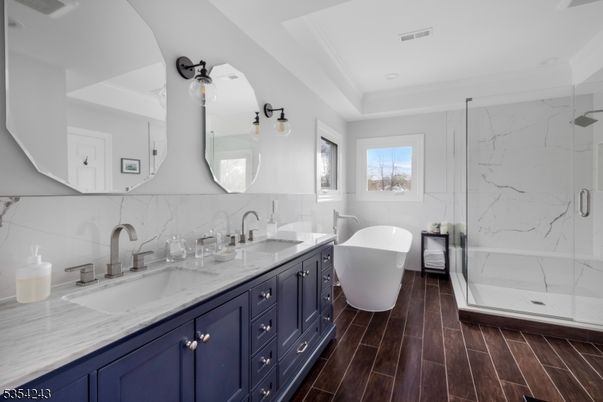 Bathroom, Dual Sink Vanities, Free Standing Baths, Glass Shower, Interior, Marble Walls, Recessed Lighting, Wood Texture Flooring