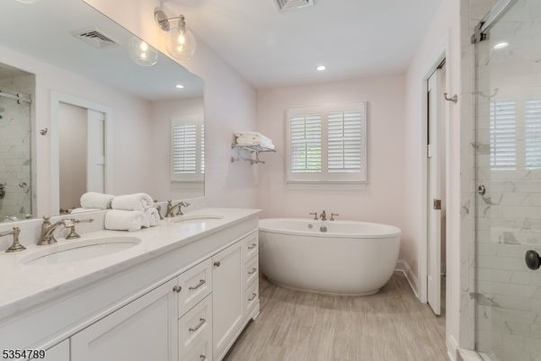 Bathroom, Dual Sink Vanities, Free Standing Baths, Glass Shower, Interior, Marble Walls, Recessed Lighting, Wood Texture Flooring
