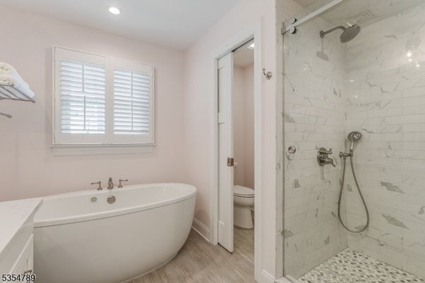 Bathroom, Free Standing Baths, Glass Shower, Interior, Marble Walls, Recessed Lighting, Wood Texture Flooring