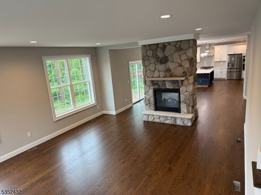 Empty room, Fireplace, Interior, Kitchen, Pendant Lights, Recessed Lighting, Stainless Steel Appliances, Stone Walls, Wood Texture Flooring