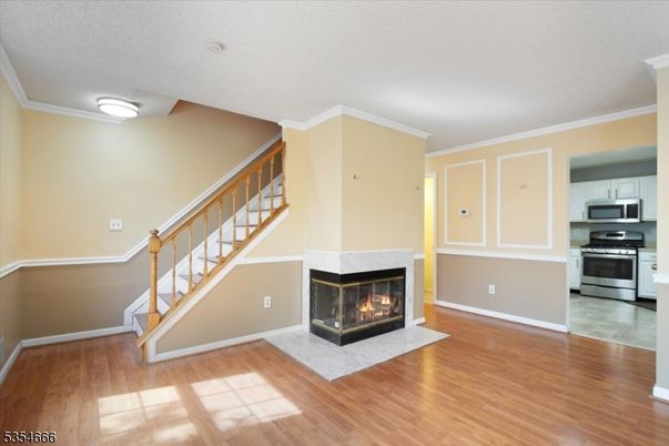Empty room, Fireplace, Interior, Kitchen, Stainless Steel Appliances, Wood Texture Flooring