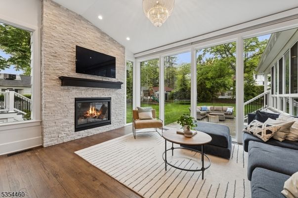 Chandelier, Fireplace, Interior, Living room, Recessed Lighting, Stone Walls, Sun Room, Wood Texture Flooring