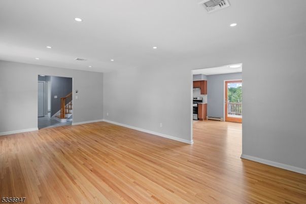 Empty room, Interior, Kitchen, Recessed Lighting, Stainless Steel Appliances, Wood Texture Flooring