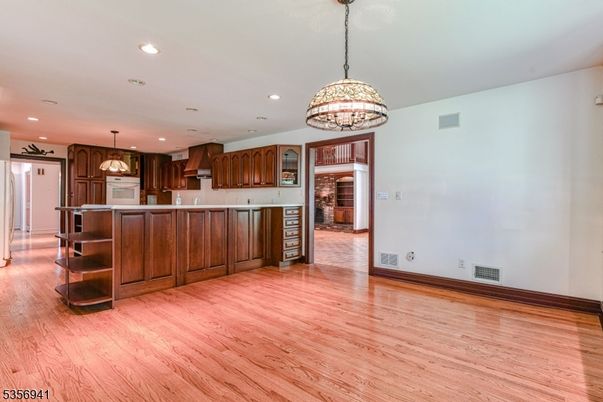Chandelier, Empty room, Interior, Kitchen, Pendant Lights, Recessed Lighting, Stainless Steel Appliances, Wood Texture Flooring
