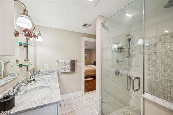 Bathroom, Dual Sink Vanities, Glass Shower, Interior, Marble, Marble Walls, Recessed Lighting, Wood Texture Flooring