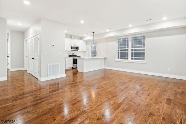 Empty room, Interior, Kitchen, Pendant Lights, Recessed Lighting, Stainless Steel Appliances, Wood Texture Flooring