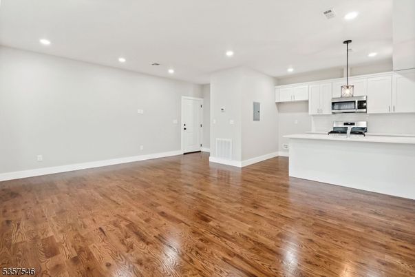 Empty room, Interior, Kitchen, Pendant Lights, Recessed Lighting, Stainless Steel Appliances, Wood Texture Flooring