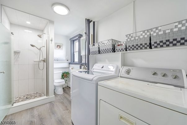 Bathroom, Glass Shower, Interior, Recessed Lighting, Washer, Wood Texture Flooring