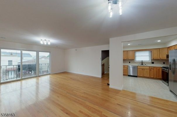 Empty room, Interior, Kitchen, Recessed Lighting, Stainless Steel Appliances, Wood Texture Flooring