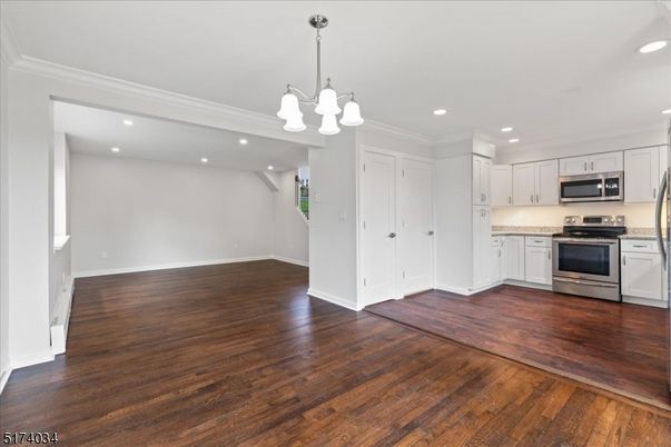 Empty room, Interior, Kitchen, Pendant Lights, Recessed Lighting, Stainless Steel Appliances, Wood Texture Flooring