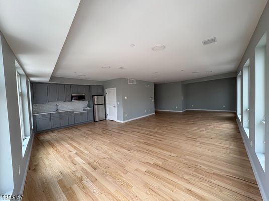 Empty room, Interior, Kitchen, Recessed Lighting, Stainless Steel Appliances, Wood Texture Flooring