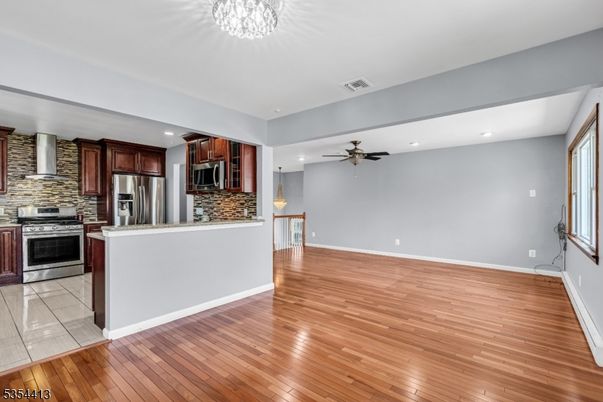 Empty room, Interior, Kitchen, Recessed Lighting, Stainless Steel Appliances, Stone Walls, Wood Texture Flooring