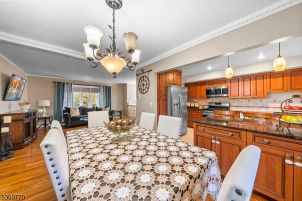 Chandelier, Dining room, Interior, Kitchen, Living room, Pendant Lights, Recessed Lighting, Stainless Steel Appliances, Wood Texture Flooring