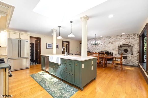 Chandelier, Dining room, Fireplace, Interior, Kitchen, Pendant Lights, Recessed Lighting, Stainless Steel Appliances, Stone Walls, Wood Texture Flooring