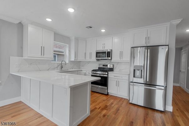 Interior, Kitchen, Marble Walls, Recessed Lighting, Stainless Steel Appliances, Wood Texture Flooring