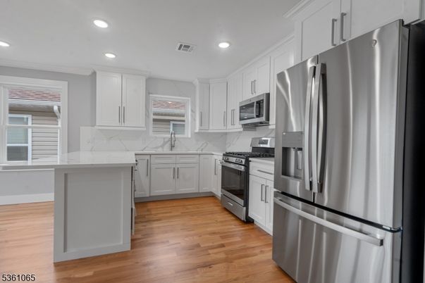 Interior, Kitchen, Marble Walls, Recessed Lighting, Stainless Steel Appliances, Wood Texture Flooring