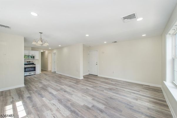 Empty room, Interior, Kitchen, Recessed Lighting, Stainless Steel Appliances, Wood Texture Flooring