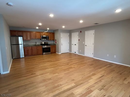 Empty room, Interior, Kitchen, Recessed Lighting, Stainless Steel Appliances, Wood Texture Flooring