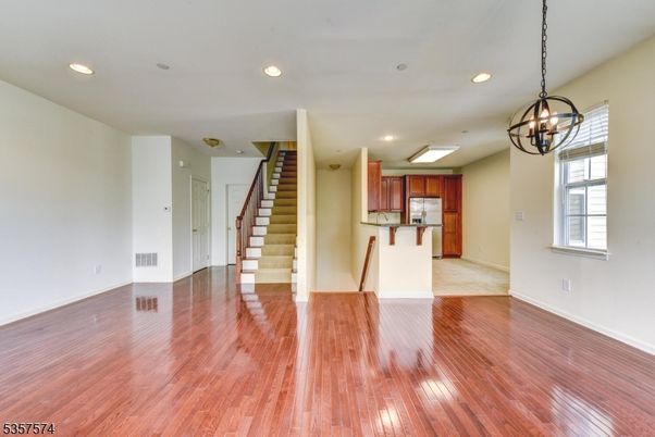 Chandelier, Empty room, Interior, Kitchen, Pendant Lights, Recessed Lighting, Stainless Steel Appliances, Wood Texture Flooring