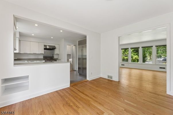Empty room, Interior, Kitchen, Recessed Lighting, Stainless Steel Appliances, Wood Texture Flooring