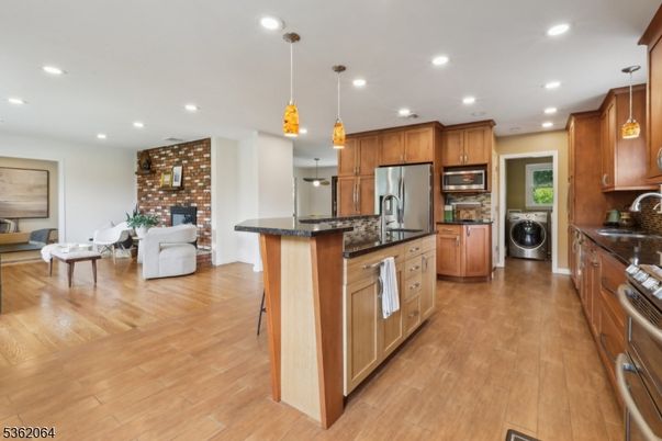 Fireplace, Interior, Kitchen, Living room, Pendant Lights, Recessed Lighting, Stainless Steel Appliances, Stone Walls, Washer, Wood Texture Flooring