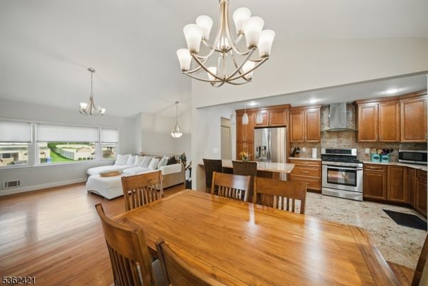 Chandelier, Dining room, Interior, Kitchen, Living room, Pendant Lights, Recessed Lighting, Stainless Steel Appliances, Wood Texture Flooring