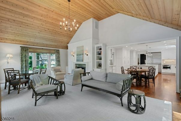 Chandelier, Dining room, Fireplace, Interior, Kitchen, Living room, Pendant Lights, Recessed Lighting, Stainless Steel Appliances, Wooden Ceilings, Wood Texture Flooring