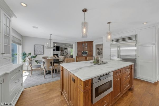 Chandelier, Dining room, Fireplace, Interior, Kitchen, Pendant Lights, Recessed Lighting, Stainless Steel Appliances, Wood Texture Flooring