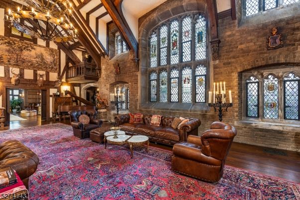 Chandelier, Fireplace, Interior, Living room, Piano, Stone Walls, Wooden Beams, Wood Texture Flooring