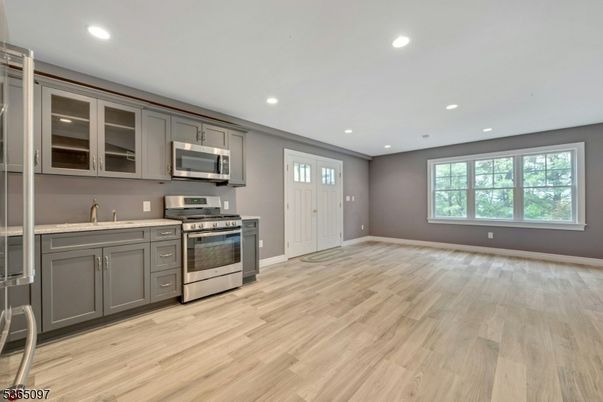 Empty room, Interior, Kitchen, Recessed Lighting, Stainless Steel Appliances, Wood Texture Flooring