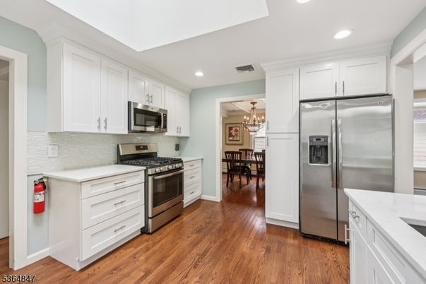Chandelier, Dining room, Interior, Kitchen, Recessed Lighting, Stainless Steel Appliances, Wood Texture Flooring