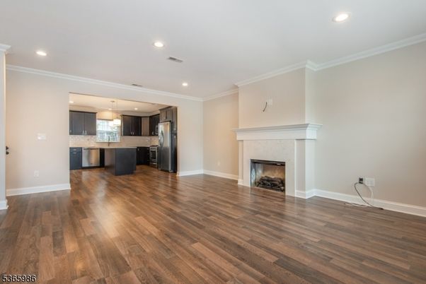 Empty room, Fireplace, Interior, Kitchen, Pendant Lights, Recessed Lighting, Stainless Steel Appliances, Wood Texture Flooring