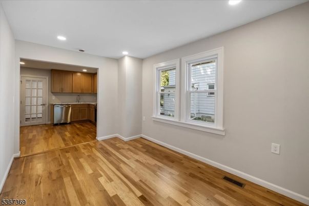 Empty room, Interior, Kitchen, Recessed Lighting, Stainless Steel Appliances, Wood Texture Flooring