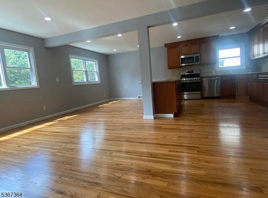 Empty room, Interior, Kitchen, Recessed Lighting, Stainless Steel Appliances, Wood Texture Flooring
