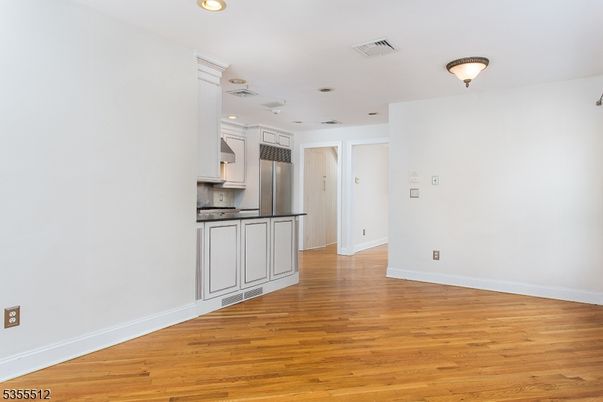 Empty room, Interior, Kitchen, Recessed Lighting, Stainless Steel Appliances, Wood Texture Flooring