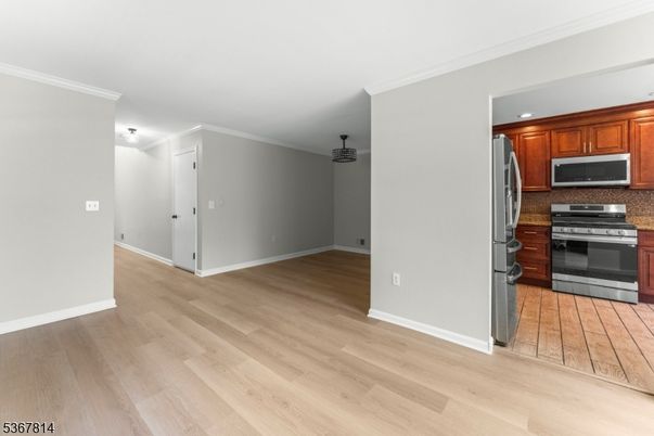 Empty room, Interior, Kitchen, Recessed Lighting, Stainless Steel Appliances, Wood Texture Flooring