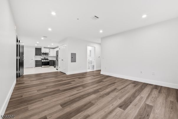 Empty room, Interior, Kitchen, Recessed Lighting, Stainless Steel Appliances, Wood Texture Flooring