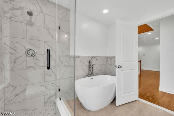 Bathroom, Free Standing Baths, Glass Shower, Interior, Marble Walls, Recessed Lighting, Wood Texture Flooring