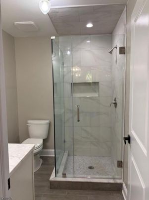 Bathroom, Glass Shower, Interior, Marble Walls, Recessed Lighting, Wood Texture Flooring