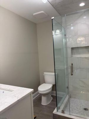 Bathroom, Glass Shower, Interior, Marble Walls, Recessed Lighting, Wood Texture Flooring
