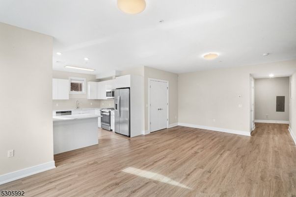 Empty room, Interior, Kitchen, Recessed Lighting, Stainless Steel Appliances, Wood Texture Flooring