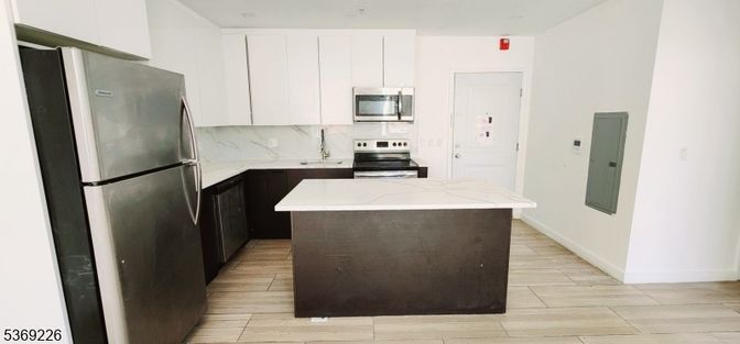 Interior, Kitchen, Marble Walls, Recessed Lighting, Stainless Steel Appliances, Wood Texture Flooring