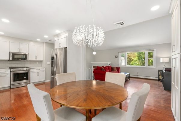 Chandelier, Dining room, Interior, Kitchen, Living room, Pendant Lights, Recessed Lighting, Stainless Steel Appliances, Wood Texture Flooring