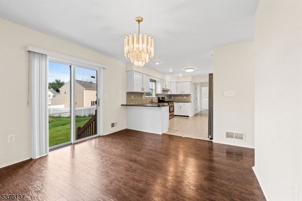 Chandelier, Empty room, Interior, Kitchen, Recessed Lighting, Stainless Steel Appliances, Wood Texture Flooring