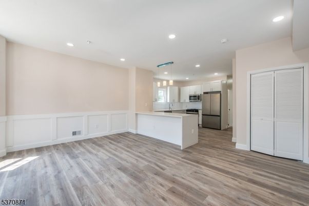 Empty room, Interior, Kitchen, Pendant Lights, Recessed Lighting, Stainless Steel Appliances, Wood Texture Flooring