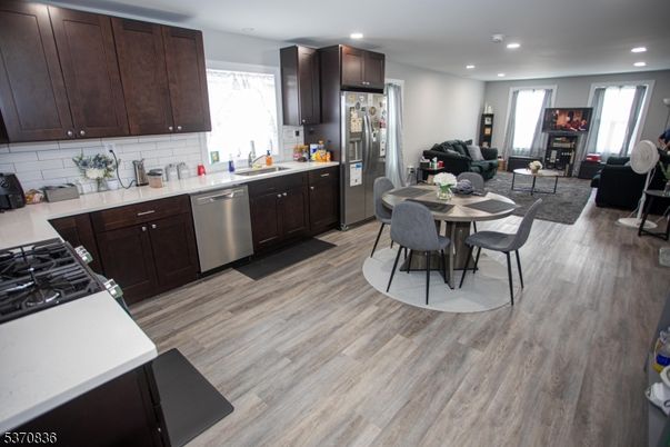 Dining room, Fireplace, Interior, Kitchen, Living room, Recessed Lighting, Stainless Steel Appliances, Wood Texture Flooring