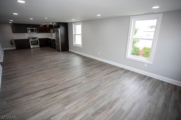 Empty room, Interior, Kitchen, Recessed Lighting, Stainless Steel Appliances, Wood Texture Flooring